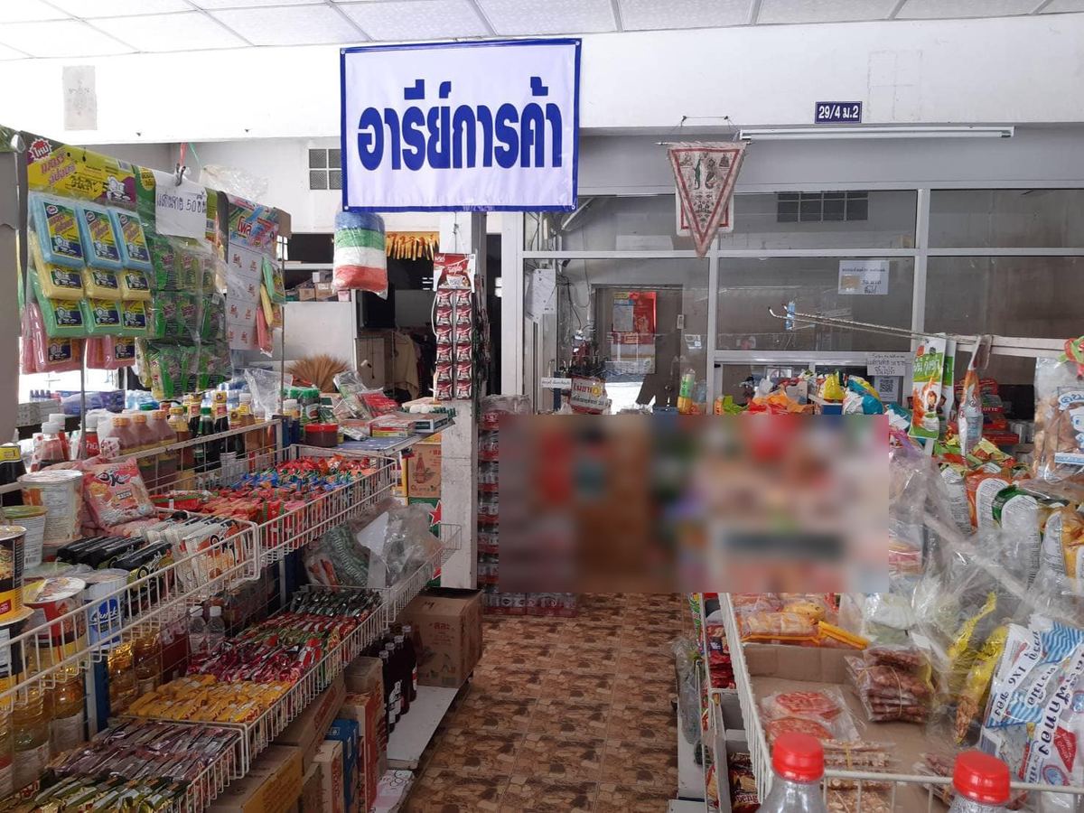 ภายในร้านอารีย์การค้า มีป้ายชื่อร้านสีน้ำเงินแขวนเหนือชั้นสินค้า