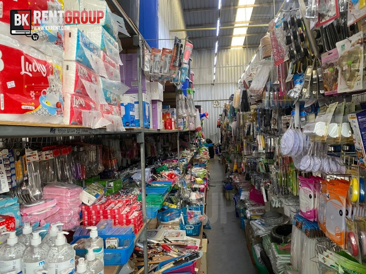 ทางเดินในร้านบอลเครื่องครัว มีเครื่องครัวและของใช้วางเต็มชั้นสองฝั่ง