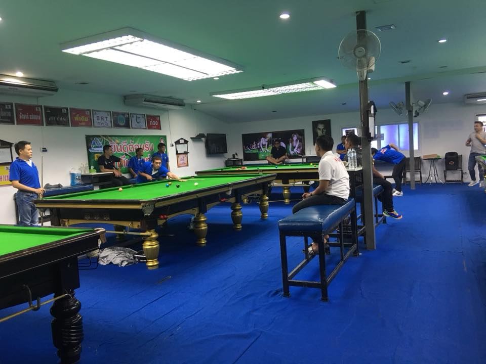 ภายใน Blue Snooker Club ปูพรมสีน้ำเงิน มีโต๊ะสนุกเกอร์หลายโต๊ะและผู้เล่น