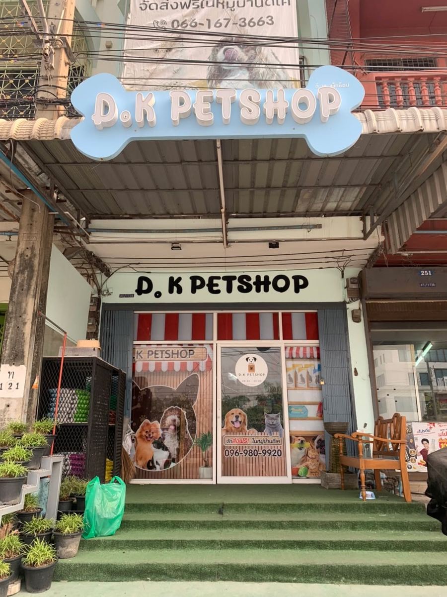 หน้าร้าน D.K PETSHOP ป้ายรูปกระดูกสีฟ้าเหนือกันสาด ขั้นบันไดหน้าร้านปูหญ้าเทียม