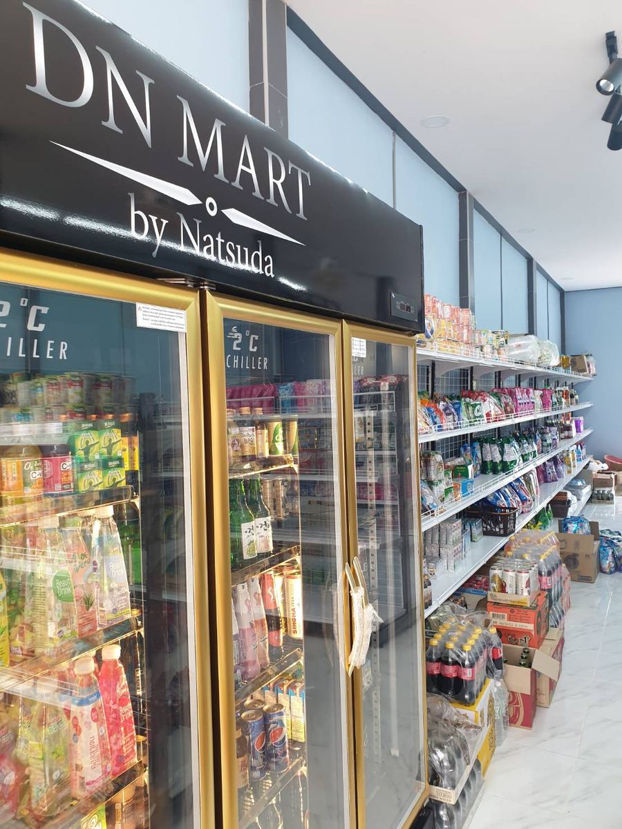ป้ายชื่อร้าน DN MART บนตู้แช่เครื่องดื่มประตูกระจก ข้างชั้นขนมและของใช้