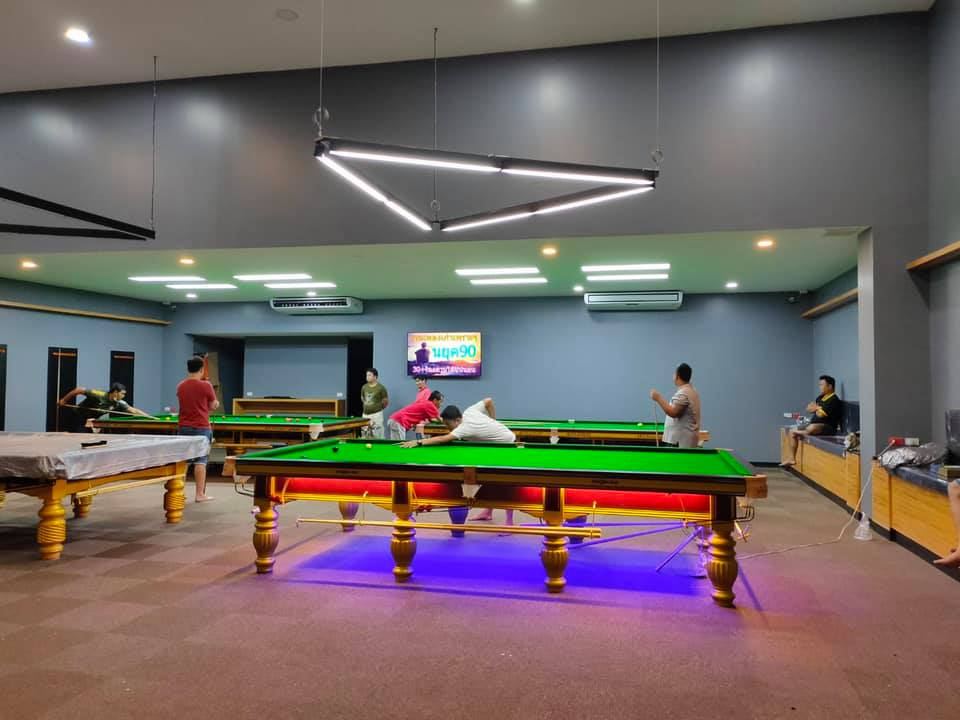 ห้องโถงของ Double B Snooker Club มีโต๊ะสนุกเกอร์หลายโต๊ะและโคมไฟสามเหลี่ยม