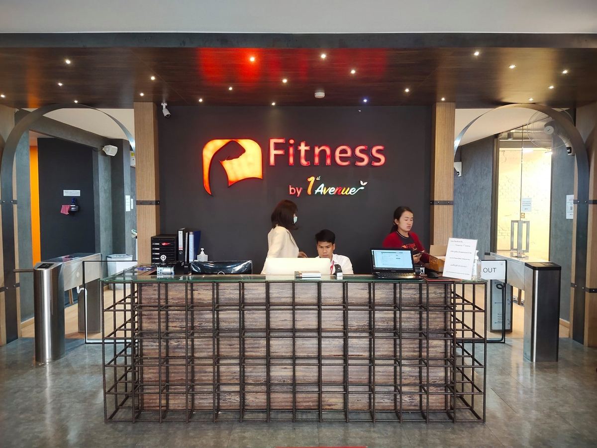 เคาน์เตอร์ต้อนรับของ First Avenue Fitness มีป้ายโลโก้ฟิตเนสบนผนัง
