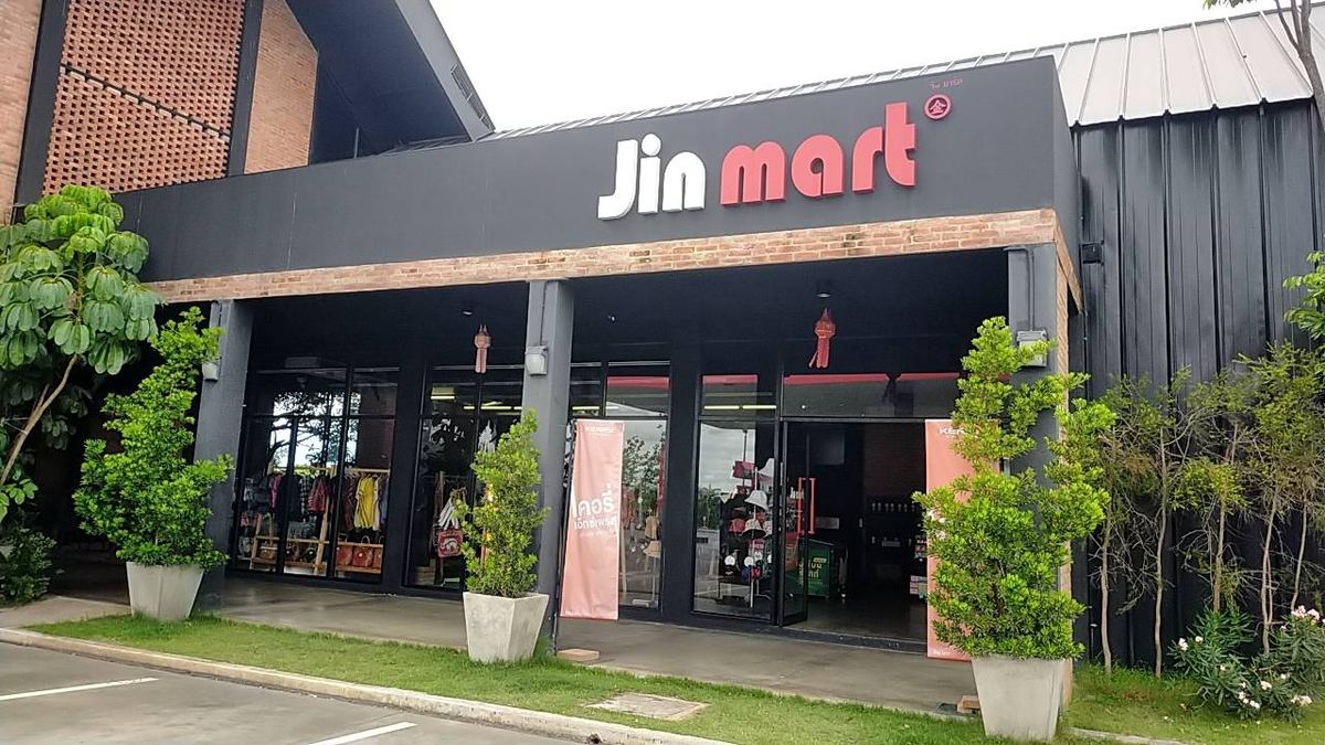 หน้าร้าน Jin mart อาคารสีดำ ป้ายชื่อร้านตัวอักษรสีขาว มีต้นไม้ปลูกหน้าร้าน