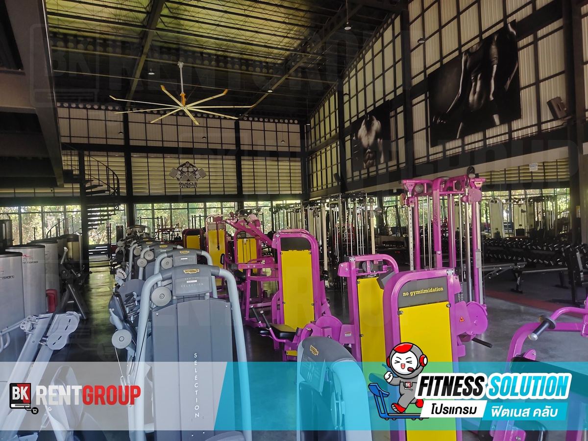 โถงฟิตเนส MUSCLE FACTORY หลังคาสูง มีเครื่องเล่นเวทหลายสีเรียงเต็มพื้นที่