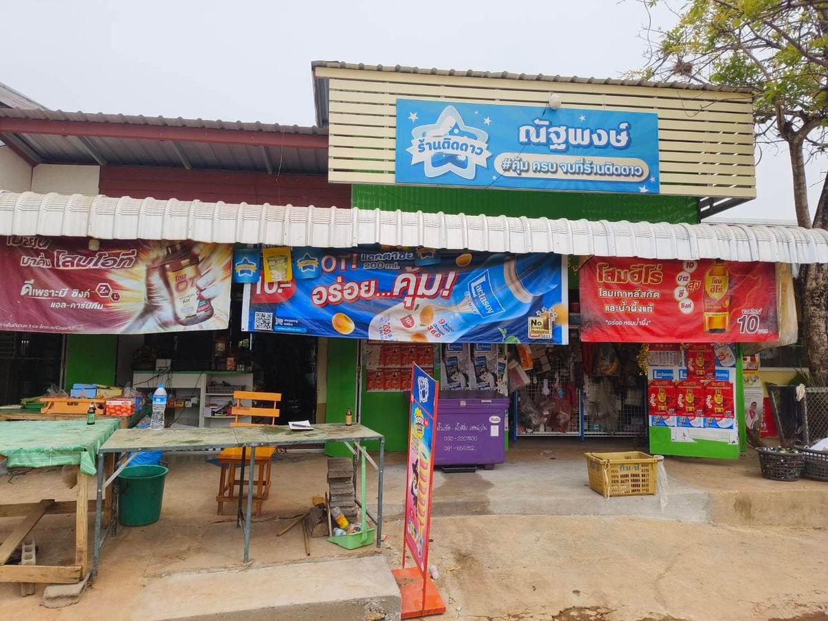 หน้าร้านณัฐพงษ์ ป้ายชื่อร้านสีฟ้า มีป้ายโฆษณาเครื่องดื่มติดหน้าร้าน