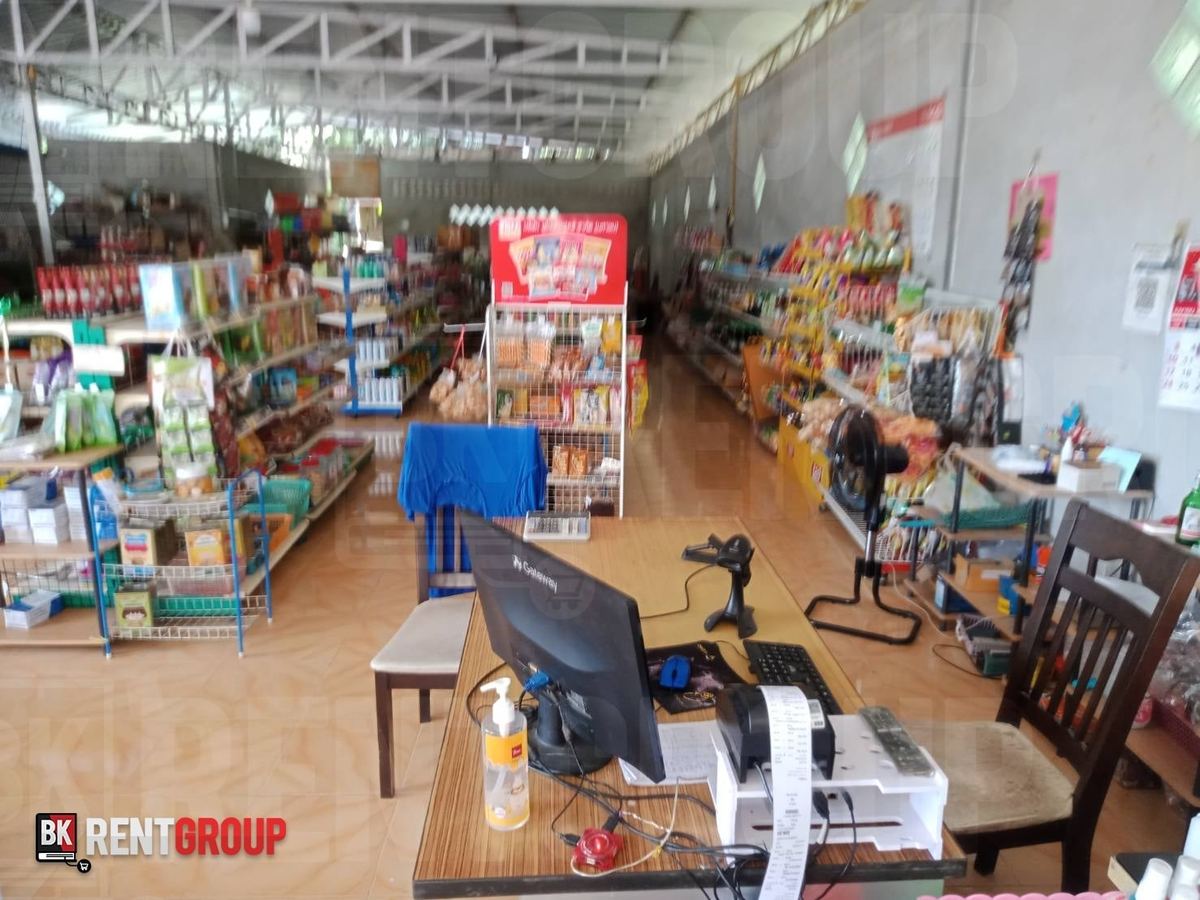 ภายในร้านพี่เอียด ชั้นขนมและของใช้หลายแถว เคาน์เตอร์มีคอมพิวเตอร์และเครื่องสแกน