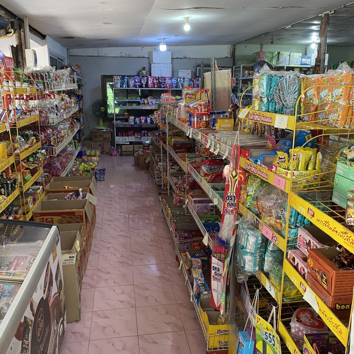 ทางเดินภายในร้านศรีเจริญ ชั้นวางขนมและของใช้เรียงเต็มทั้งสองฝั่ง