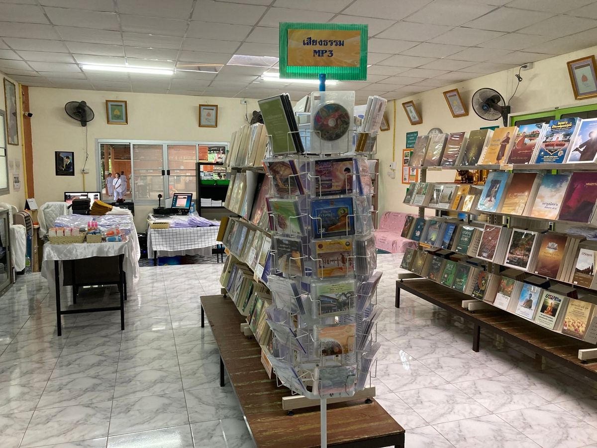 ภายในร้านสื่อธรรมะ แผงซีดีเสียงธรรม MP3 ตั้งกลางร้าน ข้างกันเป็นชั้นหนังสือธรรมะ