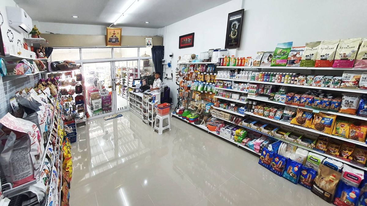 ภายในร้าน The Gang PetShop ชั้นสินค้าเรียงเป็นแถว พื้นสีขาวสะอาด
