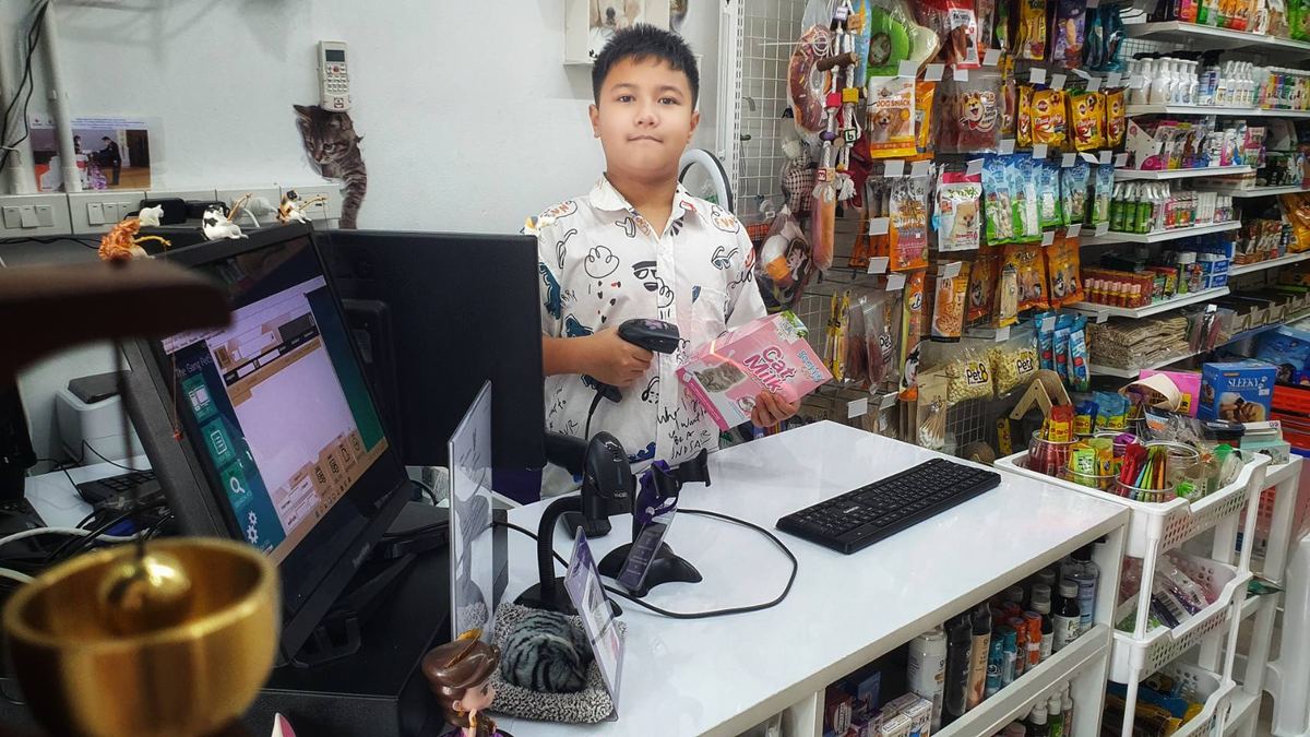 สแกนบาร์โค้ดสินค้าที่เคาน์เตอร์ ข้างชั้นขนมสัตว์เลี้ยง